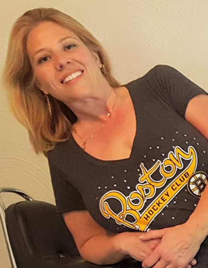 Smiling woman wearing a Boston Hockey Club shirt, related to police discovering disturbing detail about ice rink attacker family.