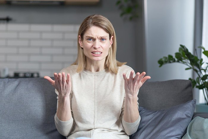 Frustrated woman at home trying to enforce family rules on boyfriend&rsquo;s son who doesn&rsquo;t live with them.