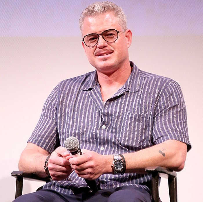 Man in glasses and patterned shirt holding a microphone, illustrating doctors breaking down commonly ignored ALS symptoms.
