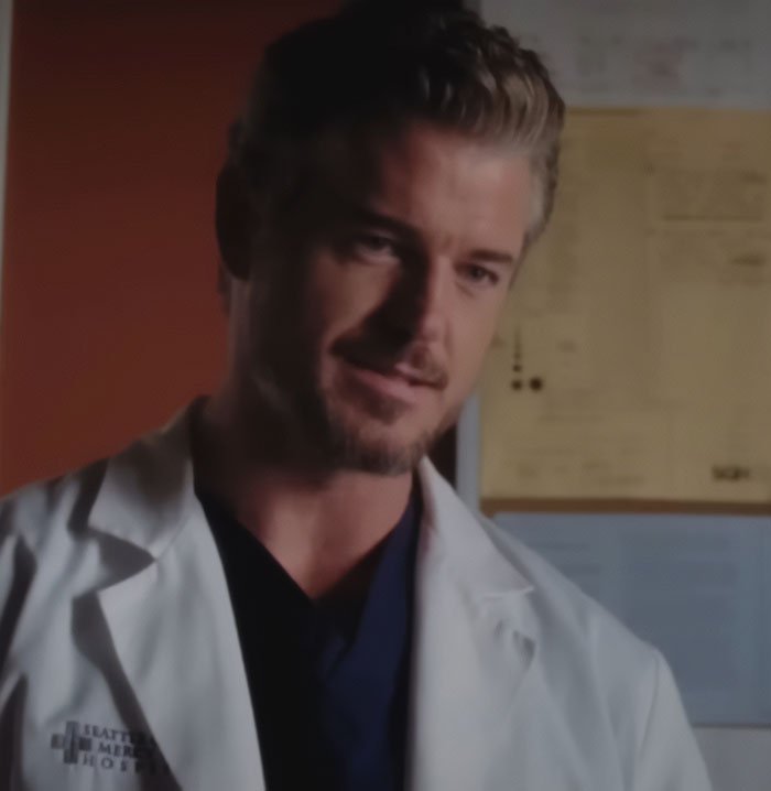Doctor in a white coat speaking indoors with a bulletin board in the background about commonly ignored ALS symptoms.