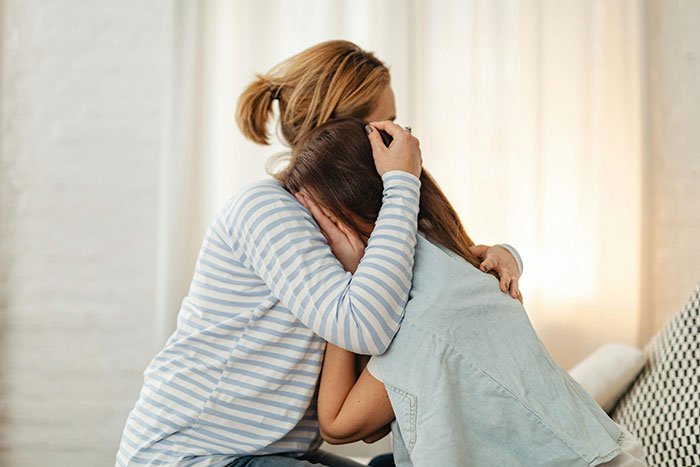 Teen comforting another, showing regret and emotional distress after being honest with her therapist about family issues involving CPS.