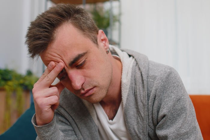 Man looking distressed and contemplative, symbolizing a guy calling off wedding after fiancée keeps secrets from him.