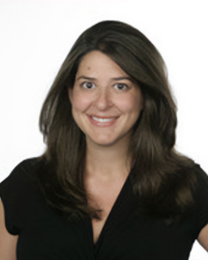 Woman with dark hair smiling in a black top, representing teacher's hot-mic moment that sparked outrage among students.