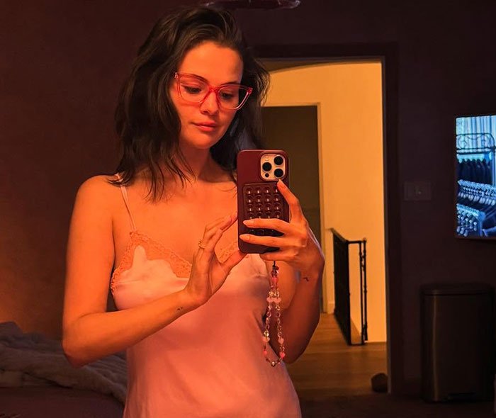 Selena Gomez taking a mirror selfie indoors, highlighting swimsuit snaps that sparked heated debate over odd detail.