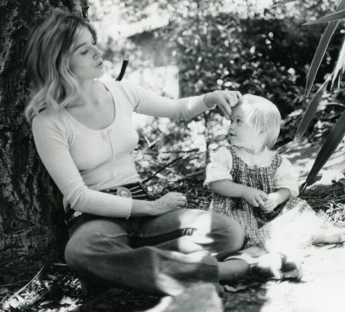 Christina Applegate sitting outside with a child, sharing a tender moment while raising awareness about multiple sclerosis.