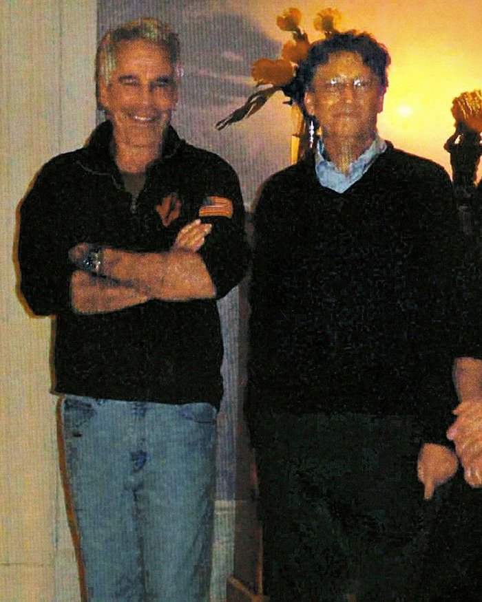 Bill Gates and Jeffrey Epstein standing indoors, with Bill Gates wearing glasses and a dark sweater.