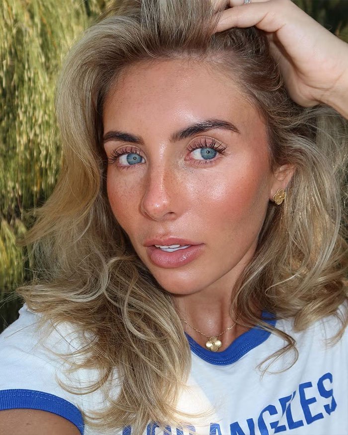 Participant from Bonnie Blue’s 400-Men Challenge with blonde hair and blue eyes sharing behind-the-scenes revelations outdoors.
