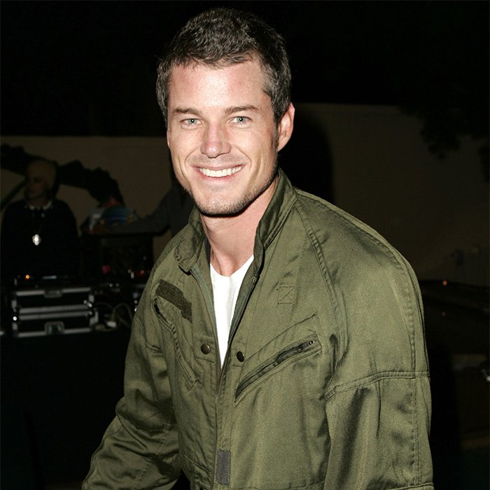 Eric Dane smiling in a green jacket at an event, illustrating details on his scandalous lifestyle and downward spiral.