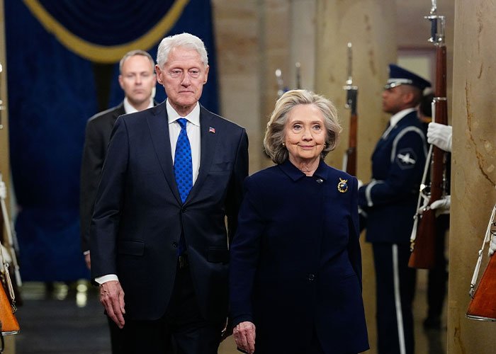 Hillary Clinton and Bill Clinton walking during a formal event, highlighting Epstein claim about Trump in political clash.