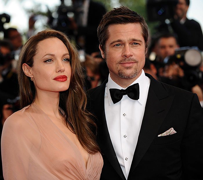 Brad Pitt and Angelina Jolie attending a red carpet event amidst photographers, highlighting Brad Pitt's kids message.