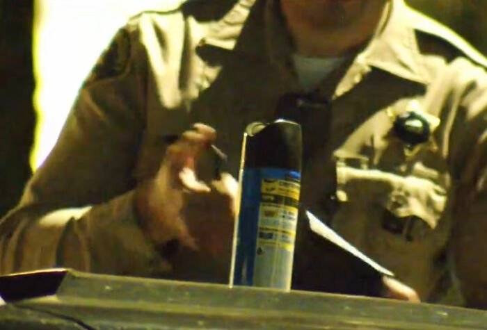 Security officer handling evidence spray can during investigation of roommate's horrifying acts on security footage.
