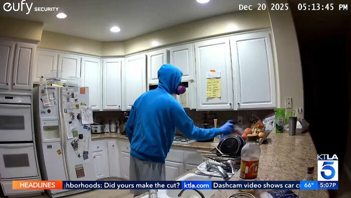 Person wearing blue hoodie and mask seen on security footage in a kitchen capturing shocking roommate's horrifying acts.