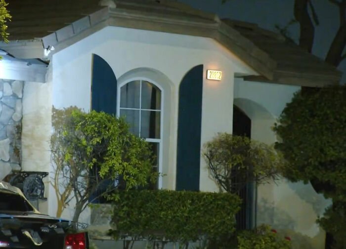 Suburban house at night where couple discovers roommate's horrifying acts on security footage after multiple ER visits.