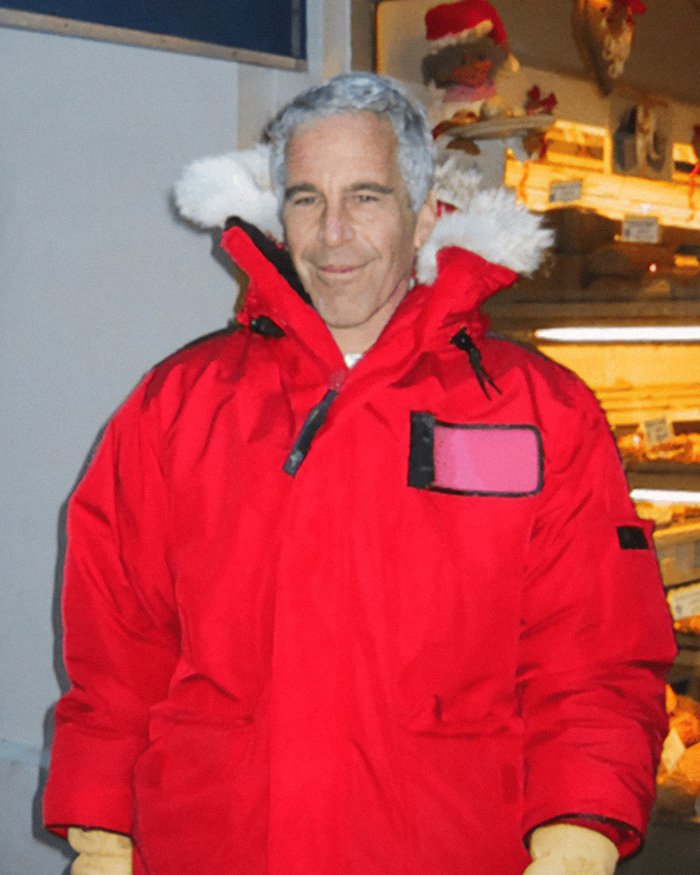 Man in red winter jacket standing outdoors near a shop, related to Jeffrey Epstein’s brother final conversation.