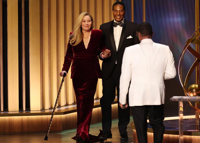 Christina Applegate using a cane on stage, highlighting doctors breaking down ignored signs of MS awareness.