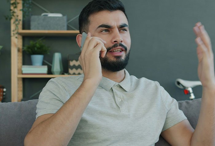 Man talking on phone with thoughtful expression, illustrating husband giving wife a second chance in relationship.