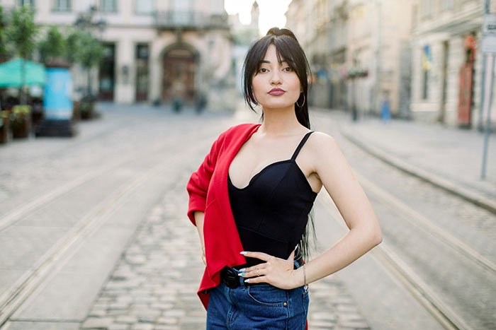 Woman standing confidently on a city street, illustrating challenges of beauty standards affecting women today.