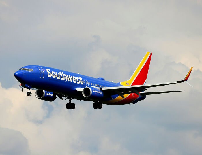 Southwest Airlines airplane in flight against cloudy sky relating to toddler seating dispute story.
