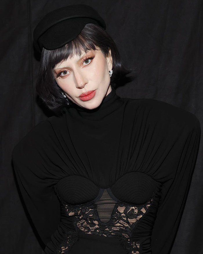 Lady Gaga in a black outfit and hat, showcasing a scary look and mannerisms that stunned fans at recent concert.