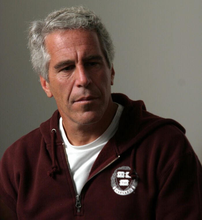 Man in casual attire with gray hair, looking down thoughtfully in a neutral setting relating to Jeffrey Epstein post mortem claims.