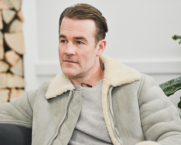 Man wearing a shearling jacket sitting indoors, illustrating commonly ignored colorectal cancer symptoms in a medical discussion.