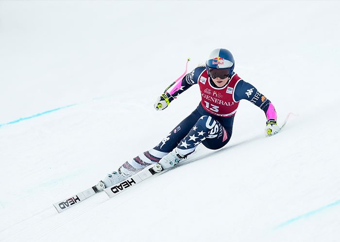 Lindsey Vonn skiing competitively, wearing USA suit, after fifth surgery on broken leg, showing determination and resilience.