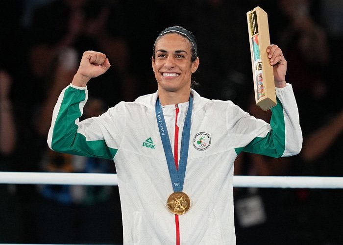 Imane Khelif celebrating with gold medal and trophy, highlighting controversy over Y chromosome gene admission.