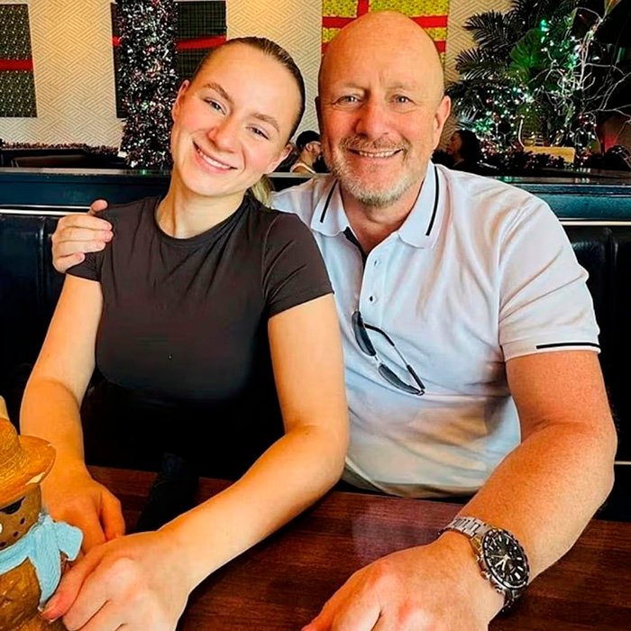 Father and daughter sitting closely at a table, depicting a family moment related to legal expert discussion on charges.