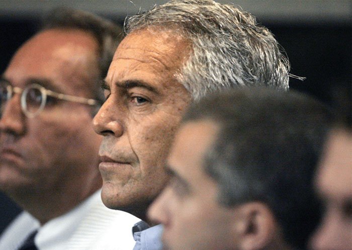 Jeffrey Epstein in a serious setting with other men, relating to sulfuric acid purchase and FBI investigation.
