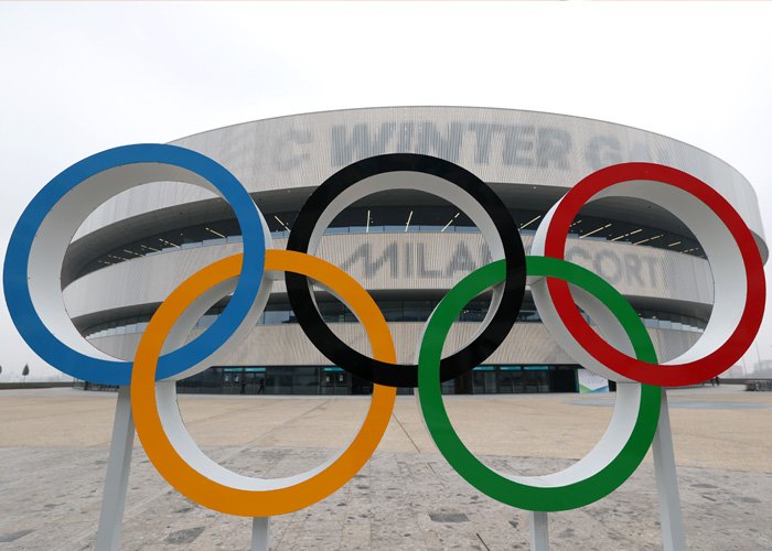 Olympic rings sculpture outside a modern arena, symbolizing controversy around injecting hyaluronic acid into the body.