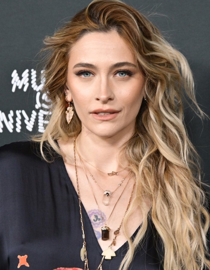 Paris Jackson with long wavy hair and layered necklaces, under fan scrutiny about her biological dad after reunion with Debbie Rowe.