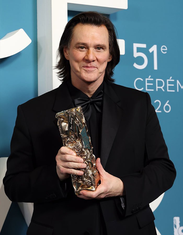 Actor Jim Carrey holding a trophy at an awards ceremony, with fans questioning viral footage appearance.