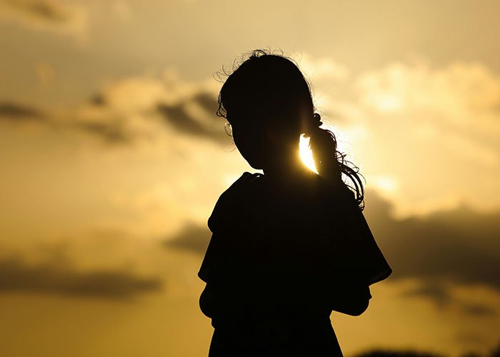Silhouette of a teen girl at sunset, symbolizing a teen making sure stepmom is miserable on wedding day.