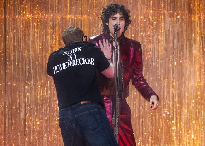 Singer pushed off stage mid performance at Brit Awards as chaos unfolds in viral video with glittering backdrop.